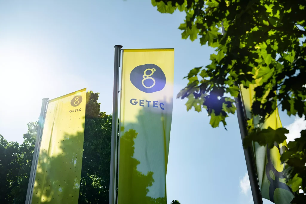 Foto der GETEC Fahnen mit Sicht auf den Himmel und Bäume